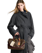 MOAH model carrying a Louis Vuitton Monogram canvas handbag with burgundy leather trim and gold-tone hardware.