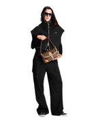 MOAH model wearing all-black outfit holding a Louis Vuitton Monogram canvas shoulder bag with cowhide leather trim
