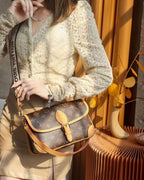 MOAH LV Diane Monogram canvas shoulder bag with leather trim and wide jacquard logo strap worn by a woman