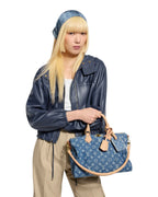 MOAH shoes model holding a blue denim Louis Vuitton Speedy Bandouliere handbag with monogram pattern and leather trim.