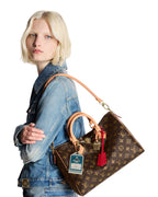 MOAH shoes model wearing a brown Louis Vuitton Speedy Bandouliere monogram canvas handbag with gold hardware